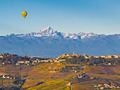 Hot air balloon flight over La Morra village with a Monviso Mountain in the background, on an autumn day, Cuneo province, Piedmont, Italy, Europe