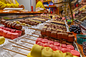 Blick auf Pralinen an einem Weihnachtsmarktstand am Victoria Square in der Abenddämmerung, Birmingham, West Midlands, England, Vereinigtes Königreich, Europa