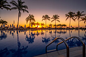 Blick auf Sonnenaufgang und Palmenreflexionen im Hotelpool bei Puerto Morelos, Karibikküste, Yucatan-Halbinsel, Mexiko, Nordamerika