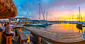 Blick auf den goldenen Sonnenuntergang, Boote und Restaurants an der Knysna Waterfront, Knysna, Westliche Kap-Provinz, Südafrika, Afrika