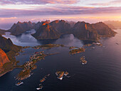 Beeindruckende Luftaufnahme des Reine-Fjords während eines Sonnenaufgangs, Reine, Moskenesoya, Lofoten-Inseln, Nordland, Norwegen, Skandinavien, Europa, mit einer Drohne aufgenommen