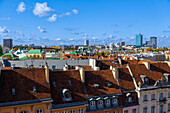 Panoramablick auf die Skyline der Stadt mit traditionellen Flachdachziegelhäusern und modernen Wolkenkratzern unter blauem Himmel mit Wolken, Warschau, Polen, Europa