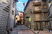 Traditionelle niedrige Häuser entlang einer Kopfsteinpflastergasse in der Hauptstadt Andorra la Vella, Andorra, Pyrenäen, Europa