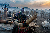 Man blowing a massive cow horn to signal the cows to come back, Mundari tribe, South Sudan, Africa