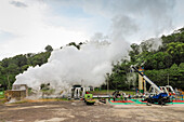 Steam chimneys, pipes and workers at a volcanic power facility run by Pertamina Geothermal Energy near Tomohon City, Lake Linow, Tomohon, North Sulawesi, Indonesia, Southeast Asia, Asia