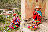 Quechua woman and child with snack, Ollantaytambo, Peru, South America