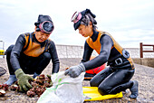 Haenyeo-Frauen, die dafür berühmt sind, bis zu zwei Minuten lang die Luft anzuhalten, sortieren ihren Fang von Muscheln, Tintenfischen, Seetang und anderen Meeresfrüchten, Jeju, Südkorea, Asien