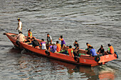 Traditional design open ferry boat with passengers in the port of this provincial capital in Sulawesi's far north. Manado, North Sulawesi, Indonesia, Southeast Asia, Asia