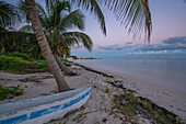 View of rustic canoe boat on beach at sunset near Puerto Morelos, Quintana Roo, Caribbean Coast, Yucatan Peninsula, Riviera Maya, Mexico, North America