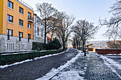 Budaer Burg mit Gebäuden neben einem Kopfsteinpflasterweg im Winter mit schmelzendem Schnee drum herum, Budapest, Ungarn, Europa