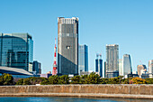 Hochhaus am Wasser mit dem ikonischen Tokyo Tower und blauem Himmel, Tokio, Honshu, Japan, Asien