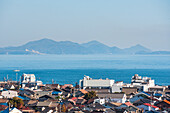 Coastal city roof tops, a calm blue sea and islands on the horizon, Tomonoura, Honshu, Japan, Asia