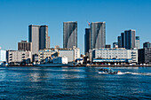 Motorboat in front of skyscrapers of Tokyo Skyline, waterfront in Habor of Harumi district, Tokyo, Honshu, Japan, Asia