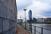 Path along the River Maas, looking along the walkway to La Tour des Finances de Leige (Tour Paradis), Liege, Belgium, Europe