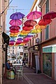 France, Var, Saint-Raphaël, multicolored umbrellas hanging over the rue de la République