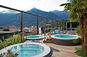 Italien, autonome Provinz Bozen, Meran, Jacuzzi auf der Dachterrasse des Hotels Meran Meran mit Blick auf die Stadt Meran und die umliegenden Berge