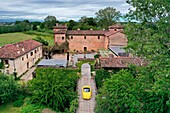 Italy, Emilia Romagna, Polesine Zibello near Parma, Antica Corte Pallavicina Hotel and restaurant, Alfa Romeo Duetto Spider yellow cabriolet (aerial view)