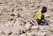 Ethiopia, Danakil depression, An Afar salt miner cutting salt bricks extracted from lake Karum