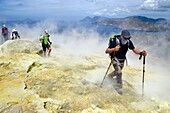 Italien, Sizilien, Äolische Inseln, UNESCO-Welterbe, Insel Vulcano, Wanderer, die den Krater des Vulkans della Fossa durch Schwefelfumarolen besteigen, im Hintergrund die Insel Lipari und dann die Insel Salina