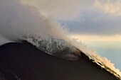 Italien, Sizilien, Äolische Inseln, von der UNESCO zum Weltnaturerbe erklärt, Insel Stromboli, Fumarolen und Wolken an den Hängen des aktiven Vulkans bei Sonnenuntergang