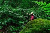 Spanien, Kanarische Inseln, La Palma, Tourist in einem Wald inmitten von tropischen Farnen