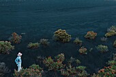 Spain, Canary Islands, La Palma, hiker on a trail in a desert and volcanic environment at sunrise