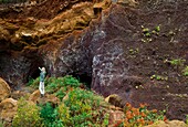 Spain, Canary Islands, La Palma, tourist on a hiking path under a vault volcanic rocks at seaside