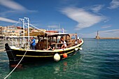 Greece, Crete, Chania, venetian port, pleasure boat going to the lighthouse