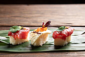 Exquisite sushi pieces artistically presented on a green bamboo leaf, highlighting traditional Japanese culinary aesthetics