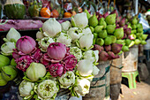 Lebendige Auslage von Lotusblumen mit rosa und weißen Blüten auf einem belebten Straßenmarkt in Bangkok, die der geschäftigen städtischen Umgebung eine natürliche, farbenfrohe Note verleiht.