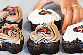 Unrecognizable crop cook holding appetizing vegan sponge cake with chocolate while cooking in kitchen of bakehouse