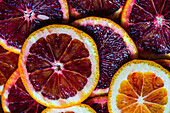 From above of vibrant close-up of freshly sliced Sicilian blood oranges and navel oranges, showcasing the rich color and juicy texture.