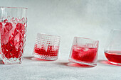 Glasses with a refreshing cherry vodka and tonic cocktail, served with ice, presented in a modern setting.