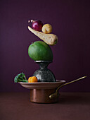 A balanced composition showcasing an assortment of fresh vegetables elegantly arranged atop vintage kitchenware against a deep purple background, creating a visually engaging and artistic scene