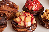 Close-up of decadent pastries topped with glaze and fresh fruit, showcasing culinary artistry and attention to detail.