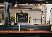 Food truck burger van outdoor in city park - Main focus on chalkboard take away sign