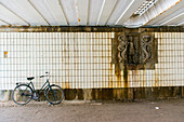 Amsterdam, Netherlands. Underneith a Vondelpark bridge an artwork and a parked bike.