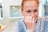 Tilburg, Niederlande. Portrait junge erwachsene rothaarige Frau mit Streetview im Hintergrund.