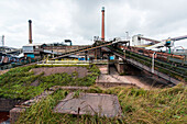 Riesige, schwere Stahlproduktionsanlage und Industriegelände, die verschiedene Arten von Stahl in einer CO2-emittierenden und -ausstoßenden Fabrik produziert. IJmuiden, Niederlande.