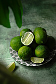 limes on a plate and green backdrop