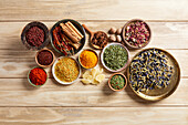 Group of herbs and spices on a light wood background