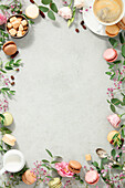 Frame made of Spring flowers,Different types of macaroons and coffee flat lay