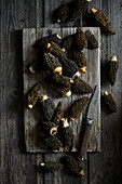 Black morels on a grey wooden background