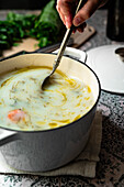 A hand stirring portuguese soup, caldo verde