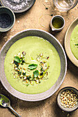 Green soup tureen with herbs on a brown background