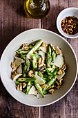 Asparagus salad with cheese and walnuts in a bowl