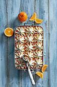 Homemade fresh vanilla-orange ice cream dessert with meringue pieces on a blue wooden background