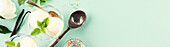 Vanilla balls, crumbles and mint leaves in a glass bowl on a pastel, light blue background, top view, banner, copy space. Summery minimal concept