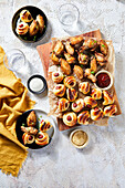 Game day food spread with chicken wings and pigs in a blanket.