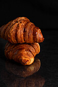 Two Fresh Croissants on Black Backdrop